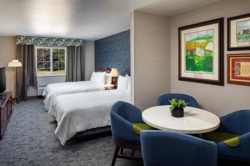 una camera d'albergo con due letti, un tavolo e delle sedie di Irish Cottage Inn & Suites a Galena