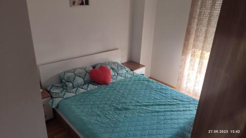 a bedroom with a bed with a heart pillow on it at Apartments Luna Kumanovo in Kumanovo