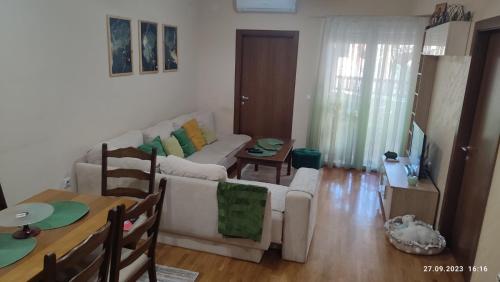 Apartments Luna Kumanovo في كومانوفو: غرفة معيشة مع أريكة وطاولة