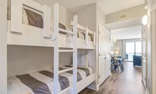 巴拿马城海滩New listing: Gulf/Beach Front Amazing Views的卧室配有白色双层床和桌子