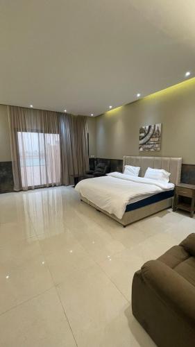 a large bedroom with a bed and a couch at درة العروس فيلا فاخره بمسبح داخلي in Durat  Alarous