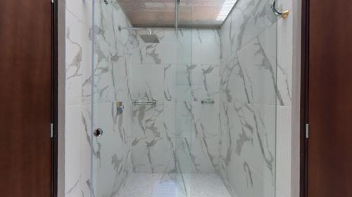 y baño con ducha y azulejos de mármol. en Estancia el Capulí, en Cuenca