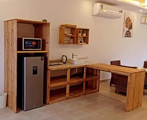a kitchen with a counter and a sink and a refrigerator at Cielo Beach Resort in Al Qaryah