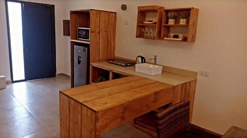 a kitchen with a wooden counter with a sink and a refrigerator at Cielo Beach Resort 
