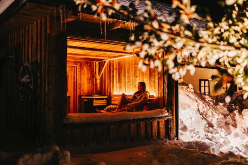 a man sitting on a bed in a cabin at Das Haus am Berg: Nestelberg17 in Lackenhof