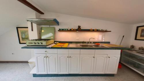 a kitchen counter with a sink and a stove at Estancia el Capulí in Cuenca