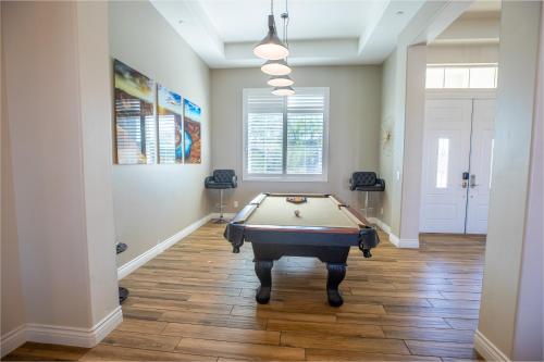 a room with a pool table on a wooden floor at 3400 SqFt House W/40Ft Heated Pool/Spa- Strip View in Henderson