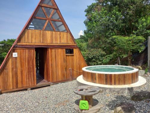 un gran edificio de madera con una piscina en el patio en Glamping RanchoEmilio en Villavicencio