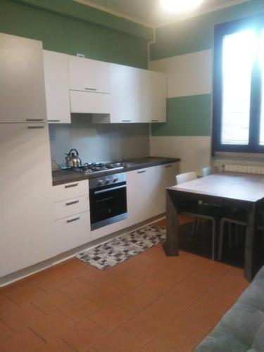 cocina con armarios blancos y estufa negra en Appartamento 4 - NEW, en Comezzano