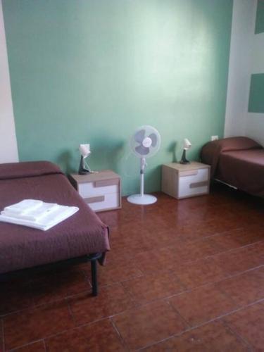 a room with two beds and a fan in it at Appartamento 4 - NEW in Comezzano