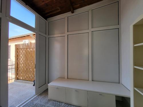 um quarto com armários brancos e uma janela em White Home Forli Centro em Forlì