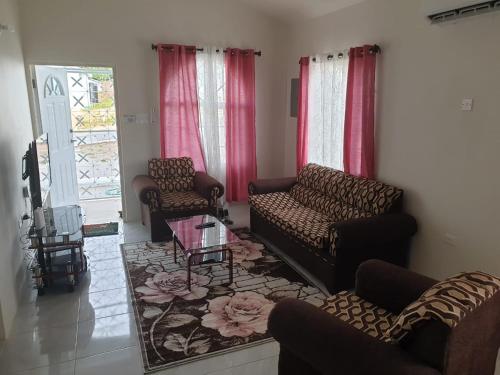 a living room with two couches and a table at CrearyStays in Discovery Bay