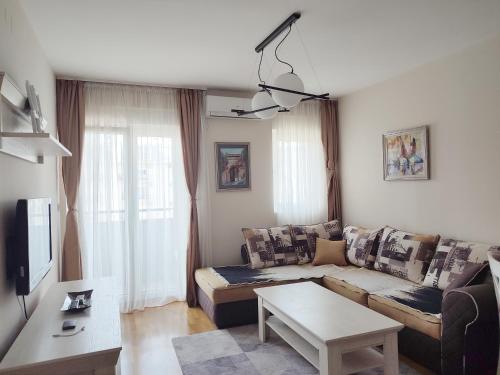 a living room with a couch and a table at CITY POINT Apartment in Podgorica