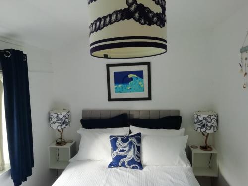 a bedroom with a bed and a chandelier at 2 bed Villa with full use of site facilities in Newquay