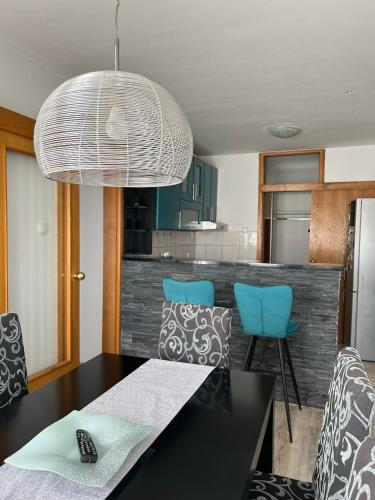 cocina con mesa negra y sillas azules en Bajka centar, en Bosanska Gradiška