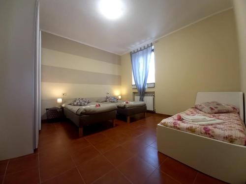 a room with two beds and a window in it at Appartamento 8 in Comezzano