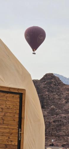 a hot air balloon is flying over a tent at Darien Luxury Camp in Wadi Rum