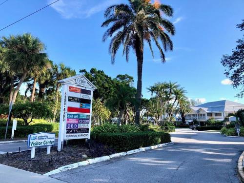 a sign in front of a street with palm trees at 7th Heaven condo in Longboat Key