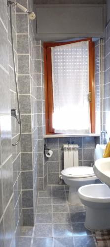 baño con aseo y lavabo y ventana en CA' DI SESTO, en Lucca