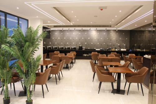 a restaurant with tables and chairs and a bar at Duqm Express Hotel in Duqm