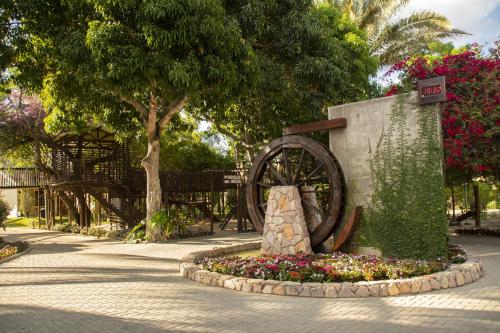 a statue of a wagon wheel in a garden at Hotel Chale Lagoa Dos Ingas in Martins