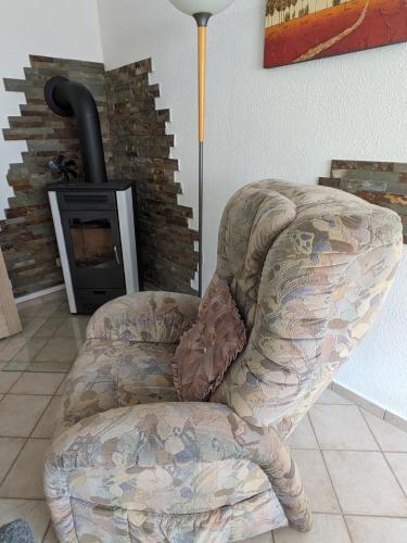 a chair in a living room with a fireplace at Idyll im Land der 1000 Seen in Liessow
