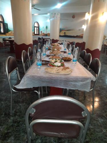 a long table with plates of food and water bottles at Oasis Panorama Hotel in Bawiti