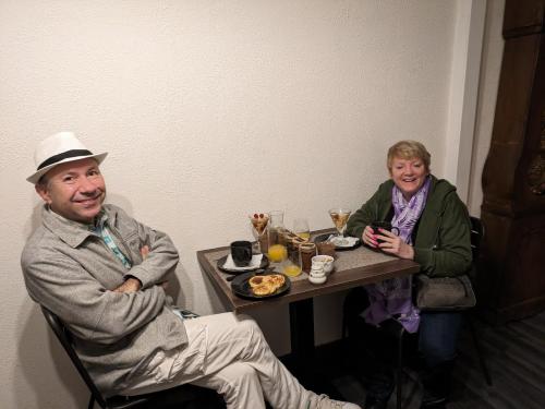 un hombre y una mujer sentados en una mesa con comida en L'ancien café, en Brocourt