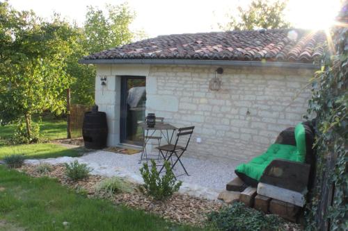 une petite maison avec un canapé vert dans une cour dans l'établissement Studio à la campagne, proche Futuroscope, à Beaumont
