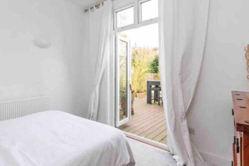a bedroom with a bed and a door to a deck at Seaside Property in Leigh-on-Sea
