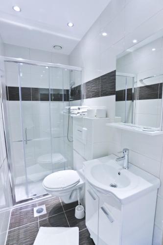 a bathroom with a shower and a toilet and a sink at Hotel Martini Zagreb Hotel and Restaurant in Sesvete