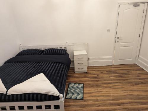 a bedroom with a bed and a dresser and a mirror at RAYAN'S LODGE STRATFORD in London