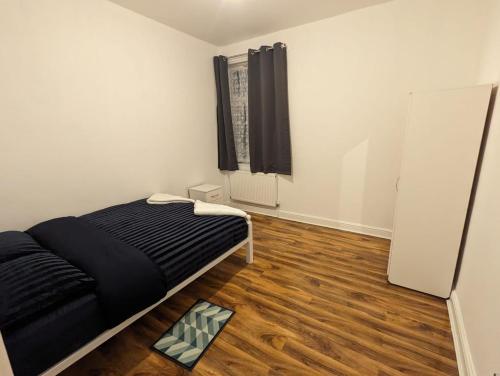 a white room with a bed and a mirror at RAYAN'S LODGE STRATFORD in London