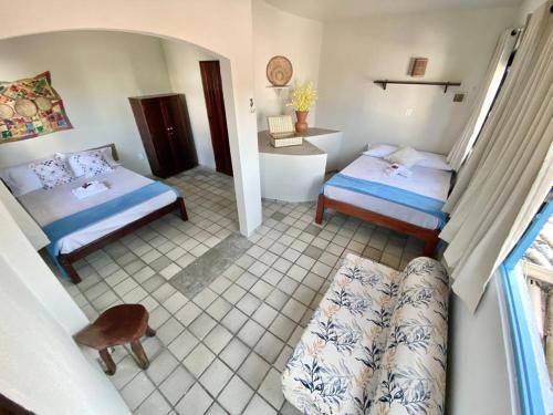 a view of a bedroom with two beds and a bathroom at Pousada Praias do Norte in São Miguel dos Milagres