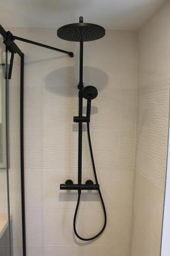 a shower with a shower head in a bathroom at L'Escale Portaise in Port-en-Bessin-Huppain