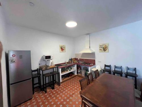 a kitchen with a refrigerator and a table and chairs at Rancho Carita in Espera