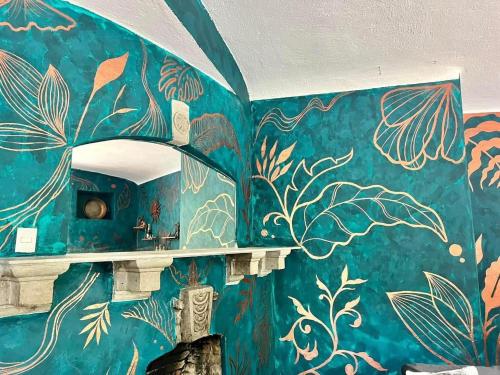 uma casa de banho com uma parede azul com desenhos em The Tower of Alebrijes in San Angel Inn em Cidade do México