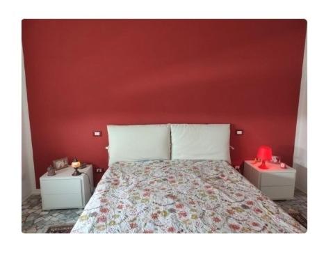 ヴィアレッジョにあるAppartamento Viareggioの赤い壁のベッドルーム1室