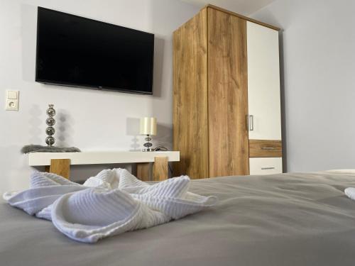 1 dormitorio con 1 cama y TV en la pared en Vulkanoase Eifel - Wellness, en Oberstadtfeld