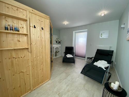 Habitación con 2 sillas y una gran puerta de madera. en Vulkanoase Eifel - Wellness, en Oberstadtfeld