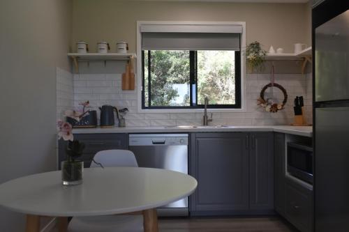 a kitchen with a white table and a window at Maleny Hinterland Escape in Witta