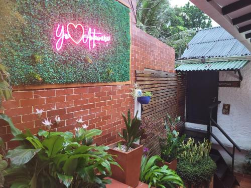 a brick wall with a neon sign on it at Hostal Antawara Tayrona in El Zaino