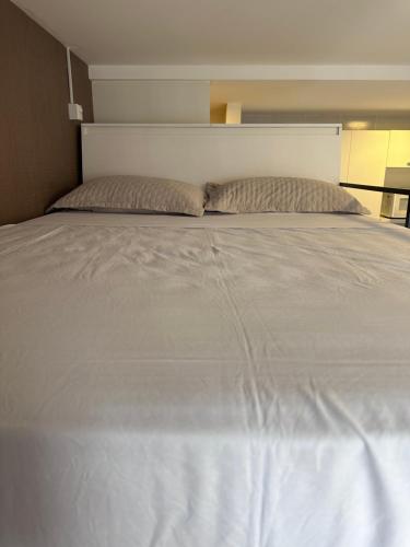 a large white bed with two pillows on it at Flat para 4 pessoas em Boa Viagem com Piscina, Wifi 500Mbps, localizado a 350 metros da Praia in Recife