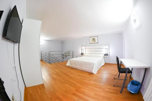 a bedroom with a bed and a desk and a television at Dimora Notar Domenico -GRAVINA IN PUGLIA- in Gravina in Puglia