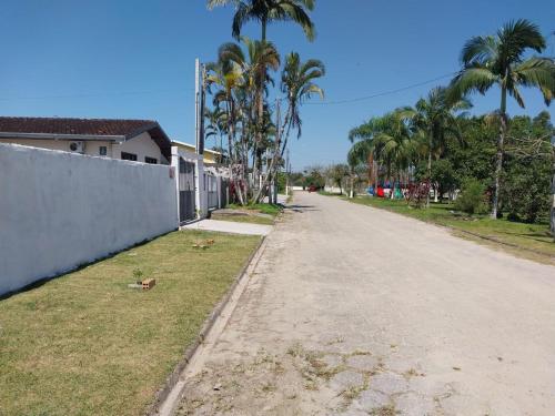 an empty street with palm trees on the side of a house at Casa disponível para diária, 300m do mar casa sozinha no terreno in Matinhos