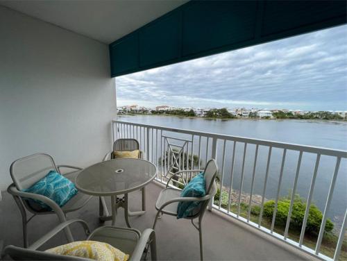 a balcony with a table and chairs and a view of the water at New Listing: Water Views, Beach, West end near 30A in Panama City Beach
