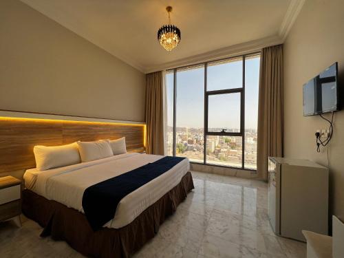 a hotel room with a bed and a large window at Taiba Karim Hotel Madina in Al Madinah