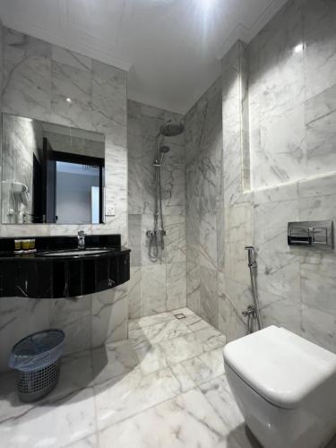 Taiba Karim Hotel Madina في المدينة المنورة: حمام مع مرحاض ومغسلة ودش