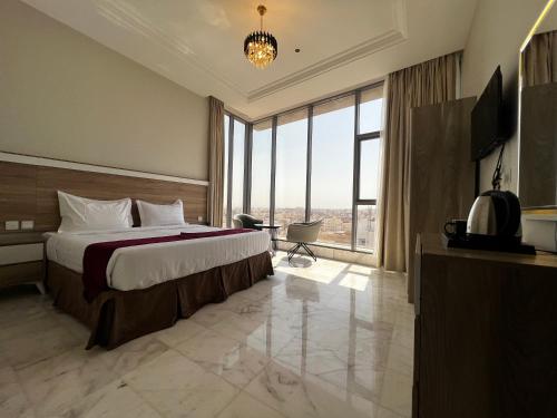 a hotel room with a bed and a large window at Taiba Karim Hotel Madina in Al Madinah