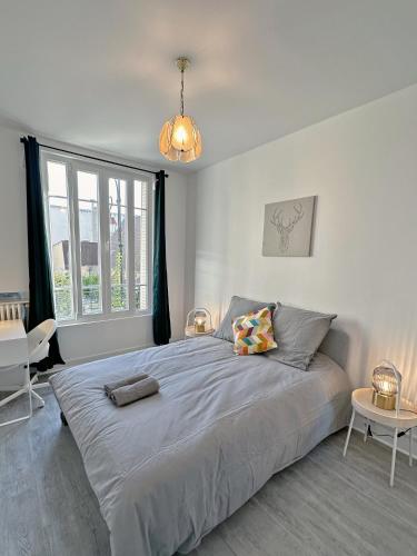 een slaapkamer met een groot bed en een groot raam bij Cosy Apartment near La Défense / Paris 4pers in La Garenne-Colombes